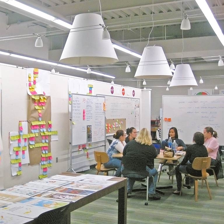 Visual communication design students meet in a collaborative workspace. 