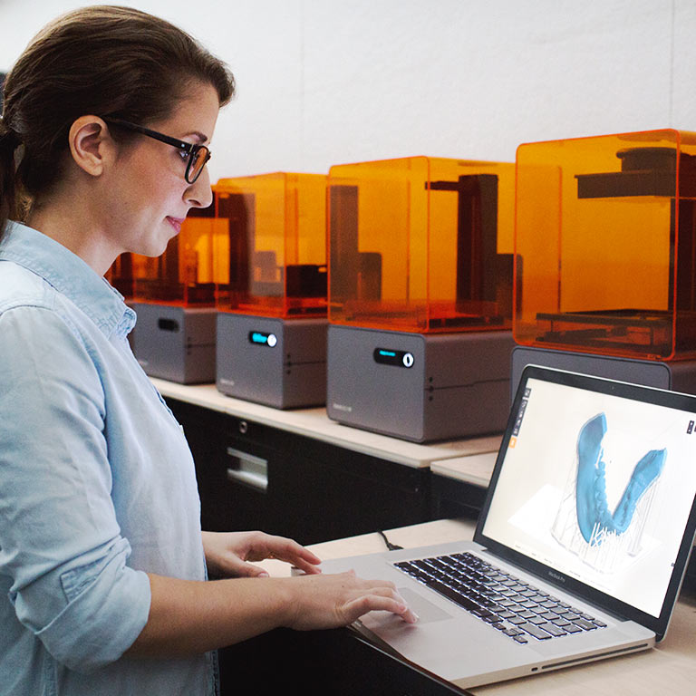 A female student designs a sculpture on her laptop.