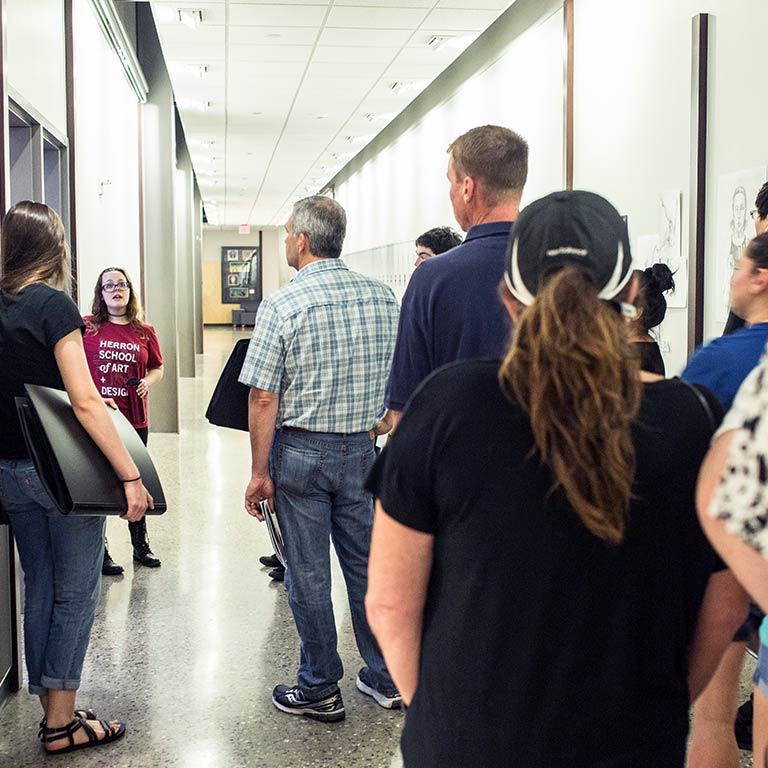 A Herron School of Art and Design student leads a group of prospective students through Eskenazi Hall.