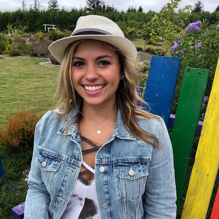 Brook Lowry sitting on an adirondack chair in a colorful garden.